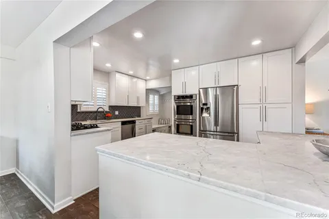 a kitchen with stainless steel appliances kitchen island sink refrigerator and cabinets