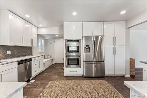 a kitchen with granite countertop a refrigerator and a stove top oven