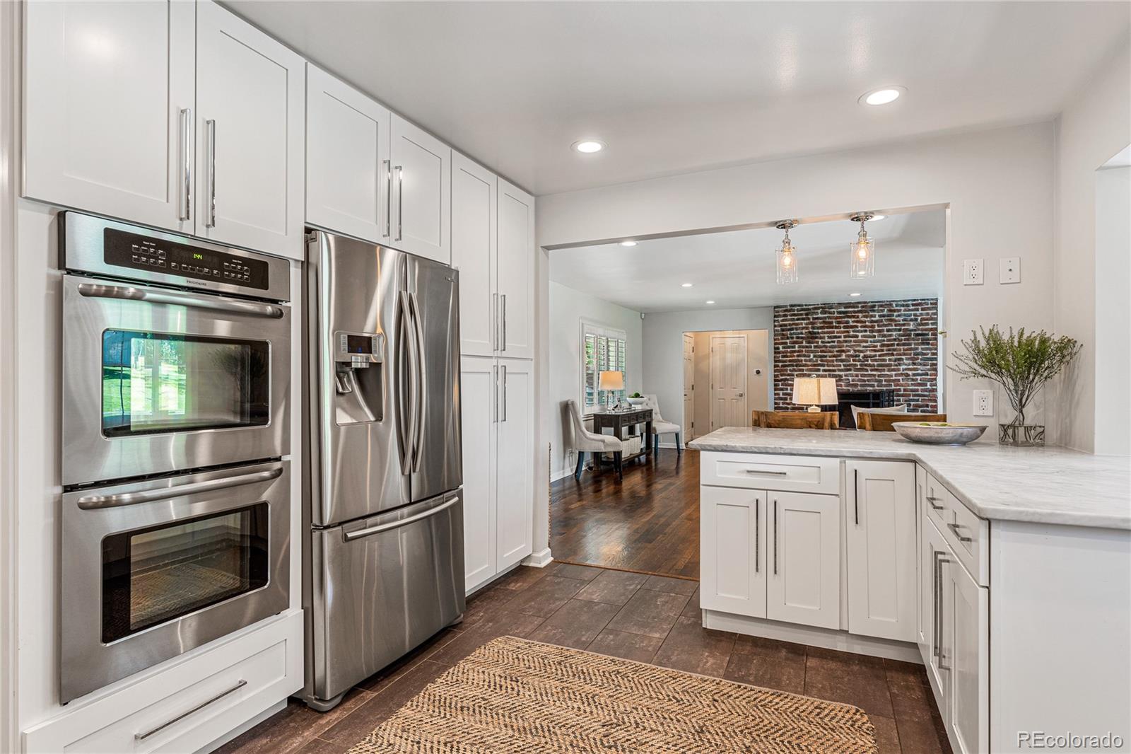 3800 East Dartmouth Avenue Denver, CO 80210 - Photo 13 of 50 a kitchen with a refrigerator and white cabinets