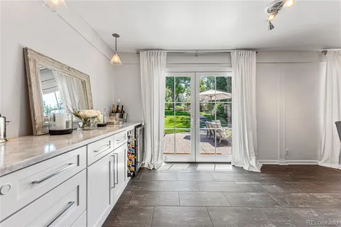 a large white kitchen with granite countertop a large window and white appliances