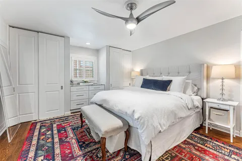 a bedroom with a bed and a lamp on a dresser