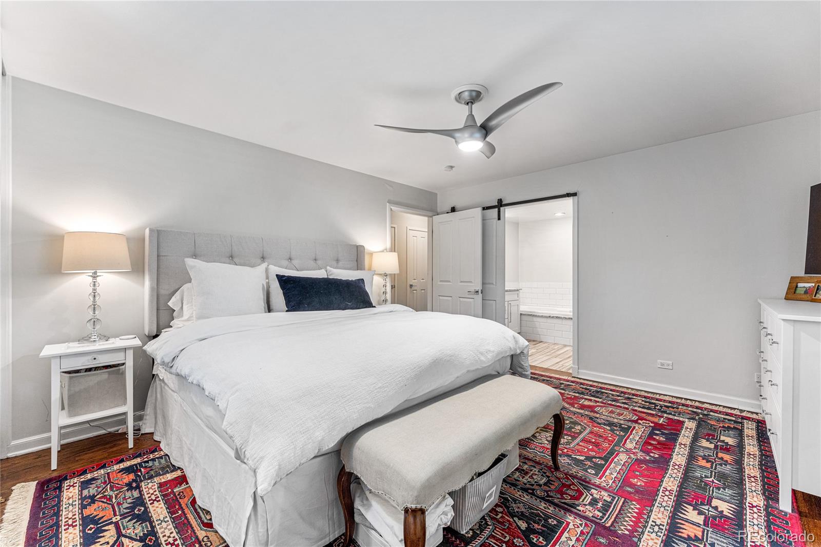 3800 East Dartmouth Avenue Denver, CO 80210 - Photo 19 of 50 a bedroom with a bed and a lamp on the dresser
