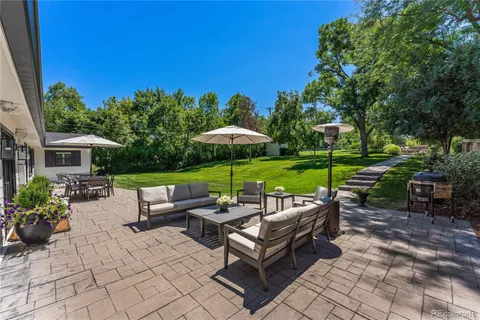 a view of a patio with a table and chairs under an umbrella