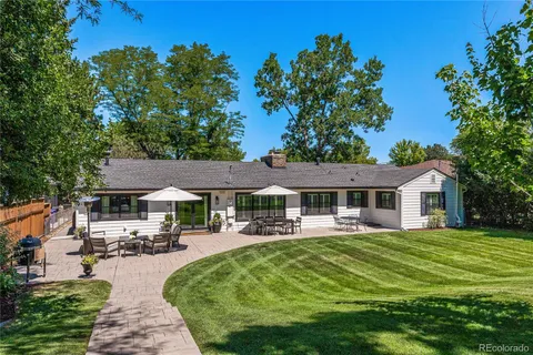 a front view of a house with garden and trees
