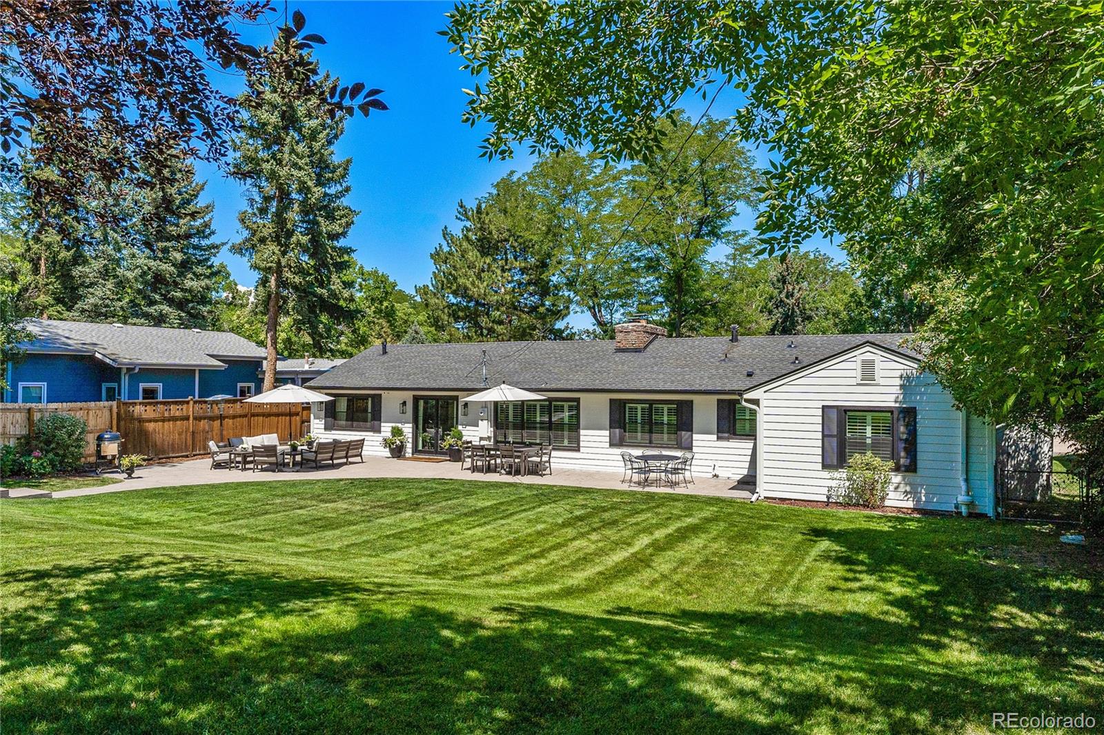 3800 East Dartmouth Avenue Denver, CO 80210 - Photo 36 of 50 a front view of a house with a yard deck and a large tree