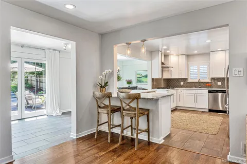a kitchen with a table chairs a sink dishwasher window and cabinets
