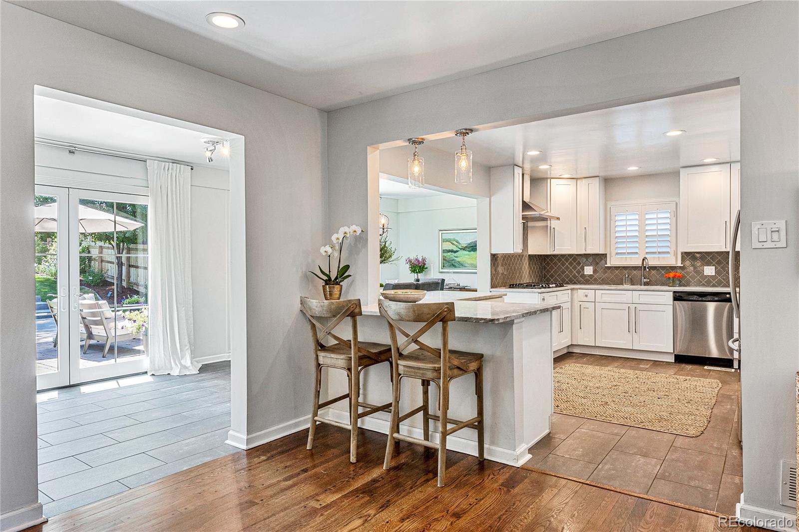 3800 East Dartmouth Avenue Denver, CO 80210 - Photo 8 of 50 a kitchen with a table chairs a sink dishwasher window and cabinets
