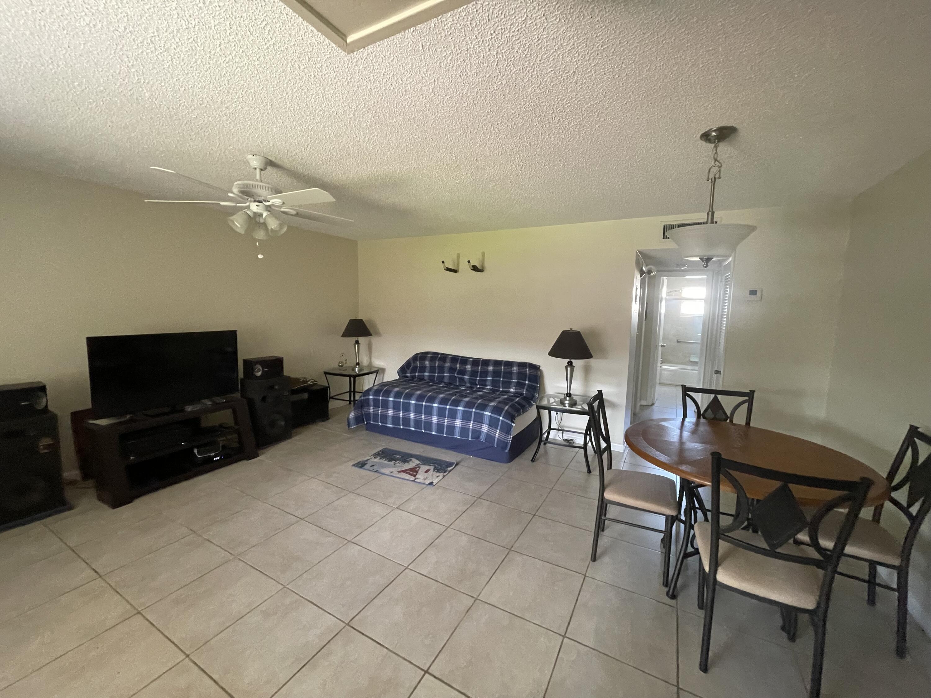 5300 Washington Street, Unit P234 Hollywood, FL 33021 - Photo 4 of 12 a living room with furniture a flat screen tv and kitchen view