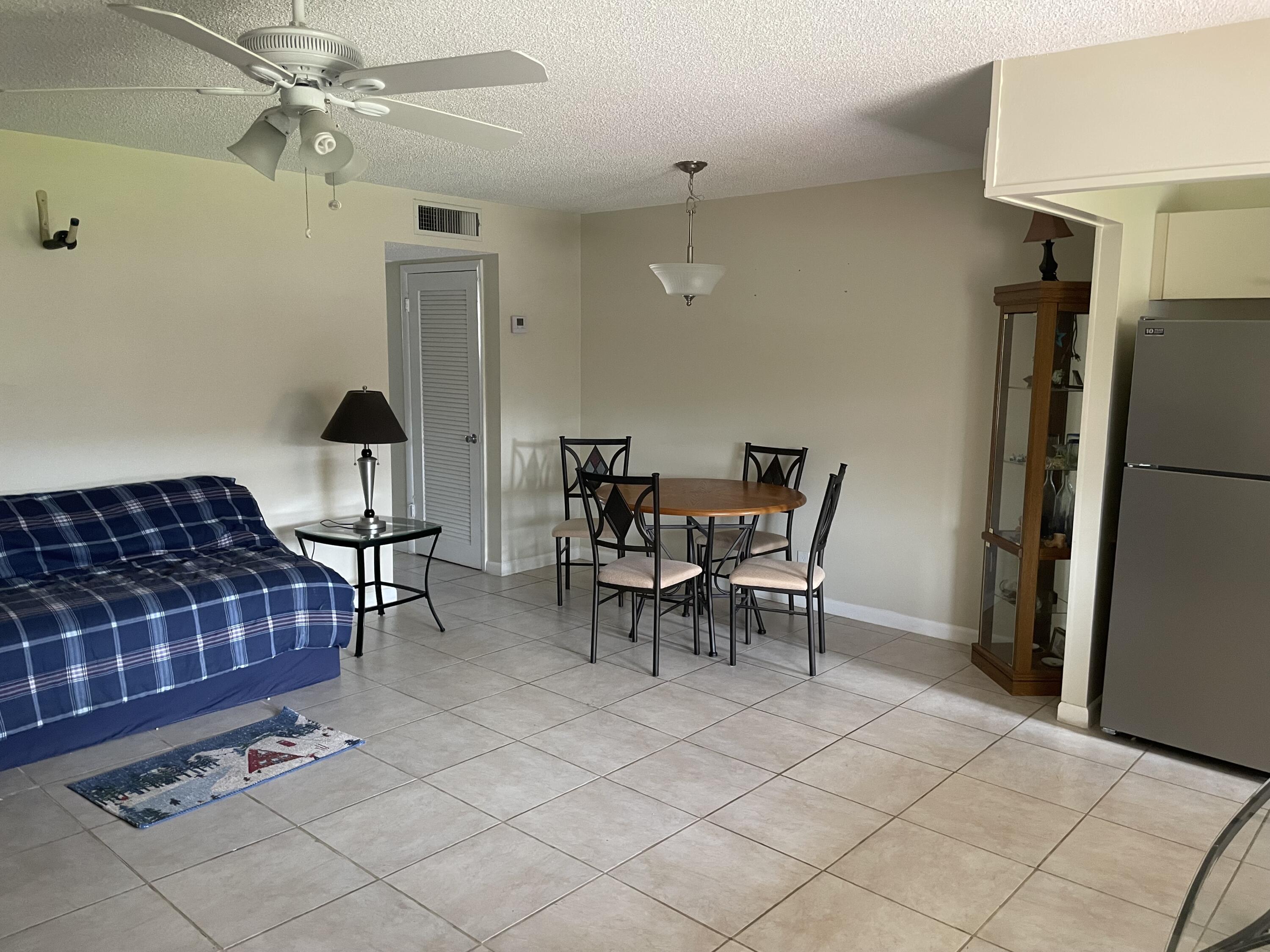 5300 Washington Street, Unit P234 Hollywood, FL 33021 - Photo 9 of 12 a dining room with furniture and a chandelier fan