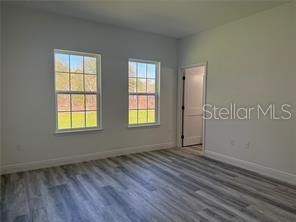 5981 Southwest 154th Place Ocala, FL 34473 - Photo 14 of 18 a view of an empty room with wooden floor and a window