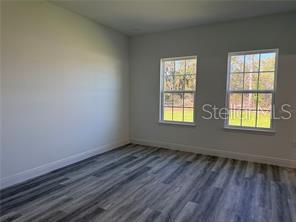 5981 Southwest 154th Place Ocala, FL 34473 - Photo 15 of 18 an empty room with wooden floor and windows