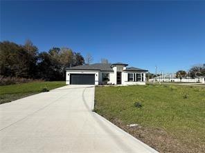 5981 Southwest 154th Place Ocala, FL 34473 - Photo 3 of 18 a front view of a house with a yard