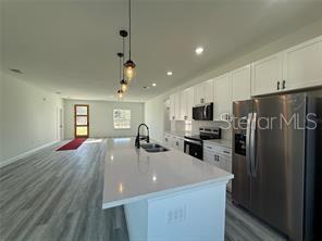 5981 Southwest 154th Place Ocala, FL 34473 - Photo 6 of 18 a kitchen with refrigerator a sink and microwave