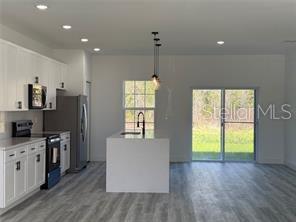 5981 Southwest 154th Place Ocala, FL 34473 - Photo 7 of 18 a open kitchen with window and wooden floor
