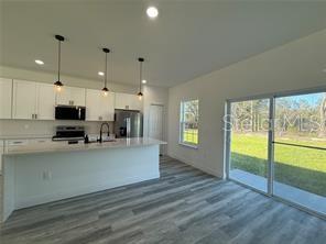5981 Southwest 154th Place Ocala, FL 34473 - Photo 8 of 18 a view of kitchen with stainless steel appliances wooden floor large window and wooden floor