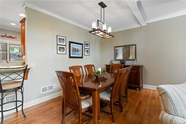 a view of a dining room with furniture a chandelier and wooden floor