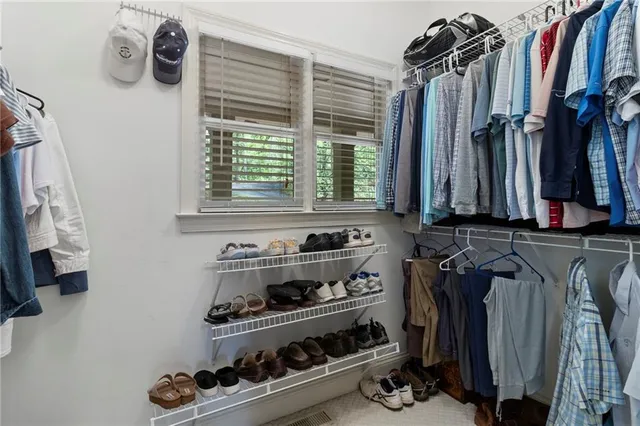 a view of walk in closet with clothes and shoes