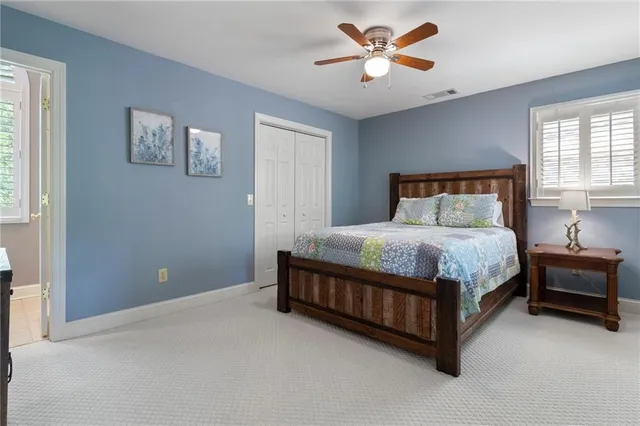 a bed sitting in a spacious bedroom next to a window