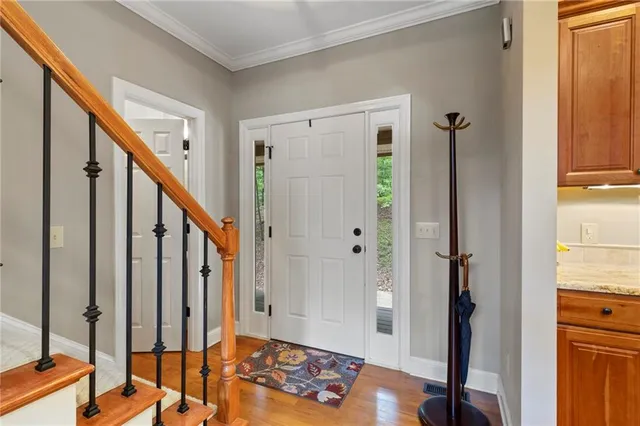 a view of a hallway with wooden floor and stairs