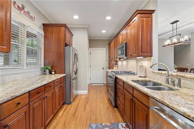 a kitchen with stainless steel appliances granite countertop a sink stove and refrigerator