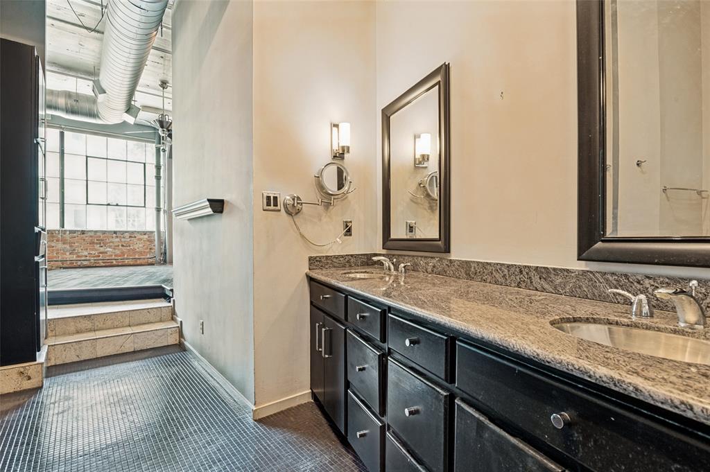 2220 Canton Street, Unit 101 Dallas, TX 75201 - Photo 9 of 20 Double vanity featuring dark wood cabinetry, integrated sinks, and a stone-finish countertop