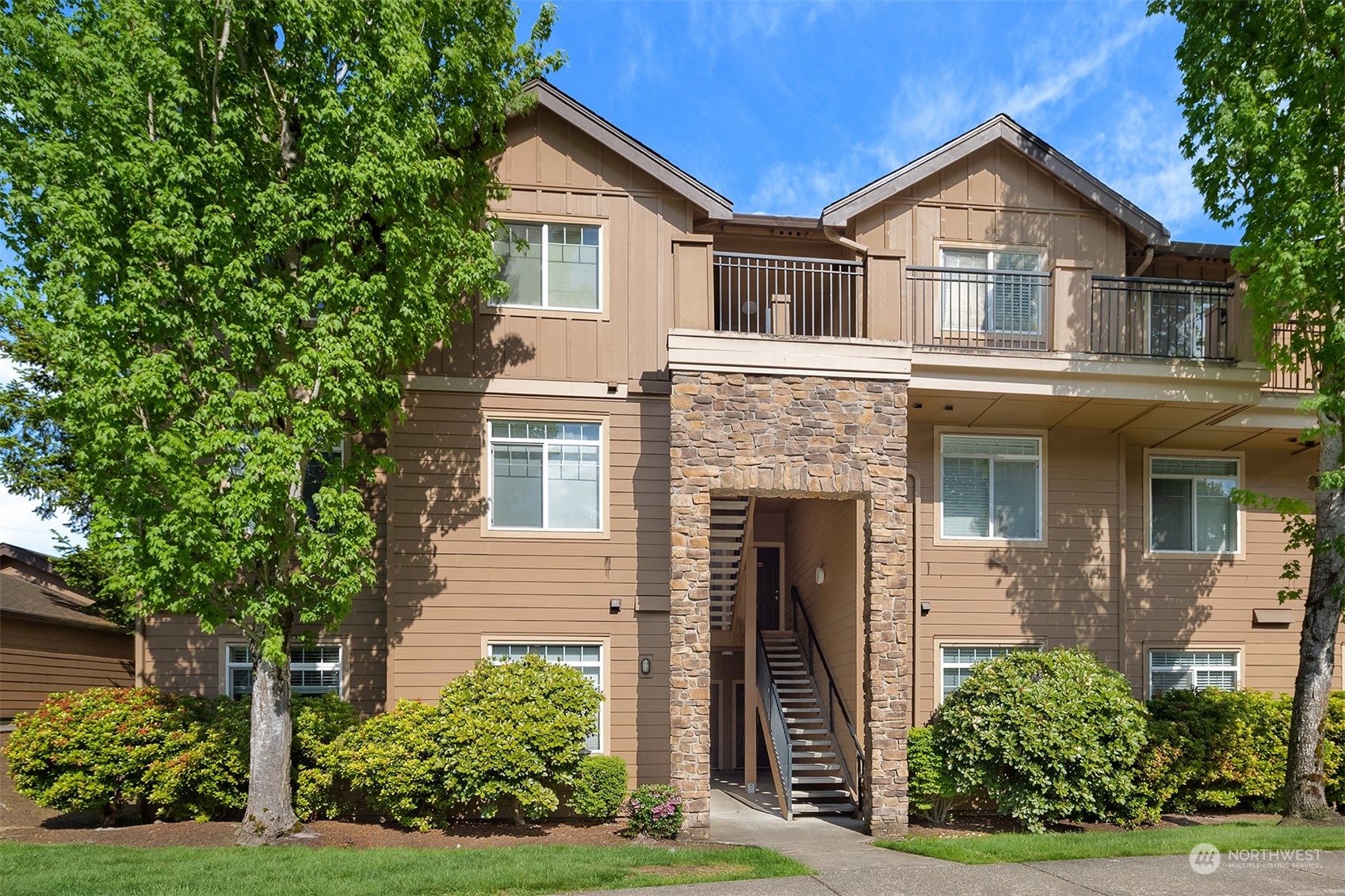 18930 Bothell Everett Highway, Unit D302 Bothell, WA 98012 - Photo 1 of 25 a front view of a house with a yard and trees