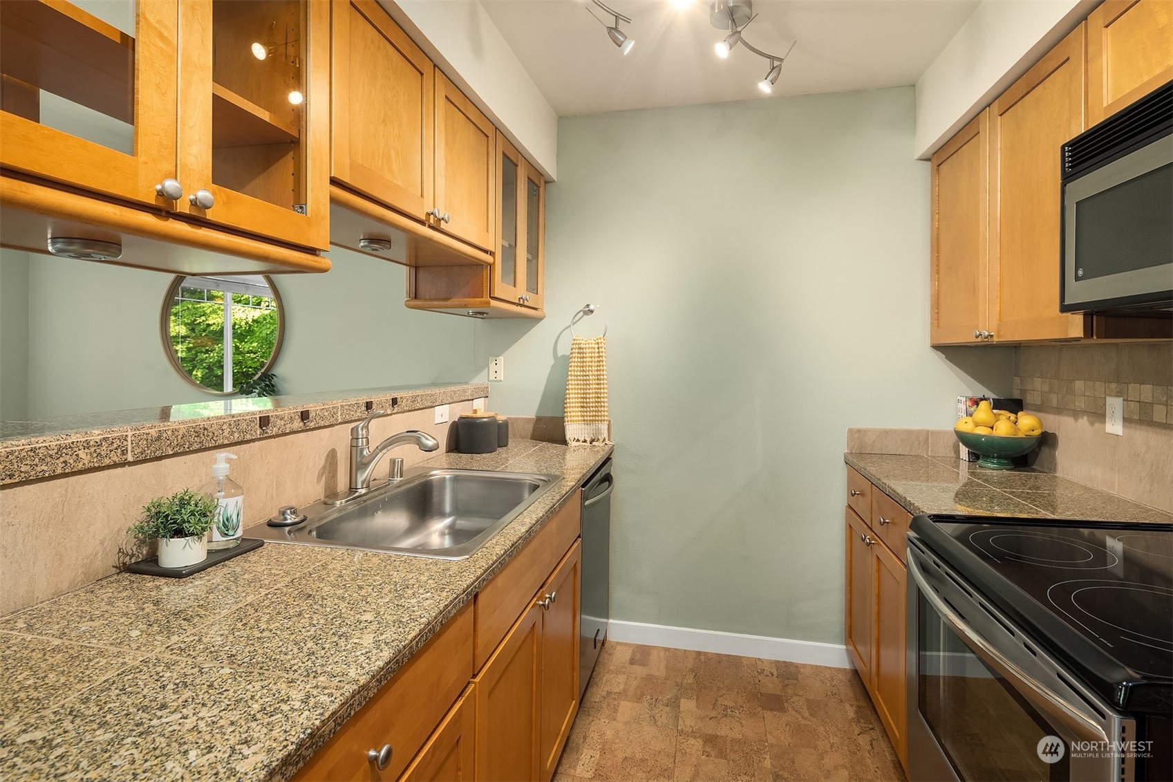 18930 Bothell Everett Highway, Unit D302 Bothell, WA 98012 - Photo 12 of 25 a kitchen with granite countertop a sink and a stove