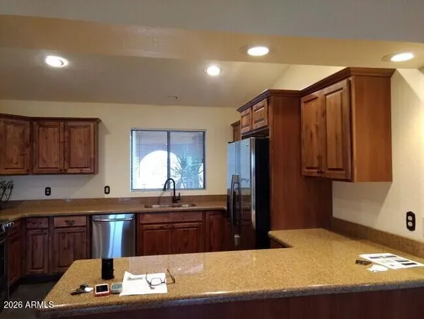 a kitchen with kitchen island granite countertop a sink stove and refrigerator