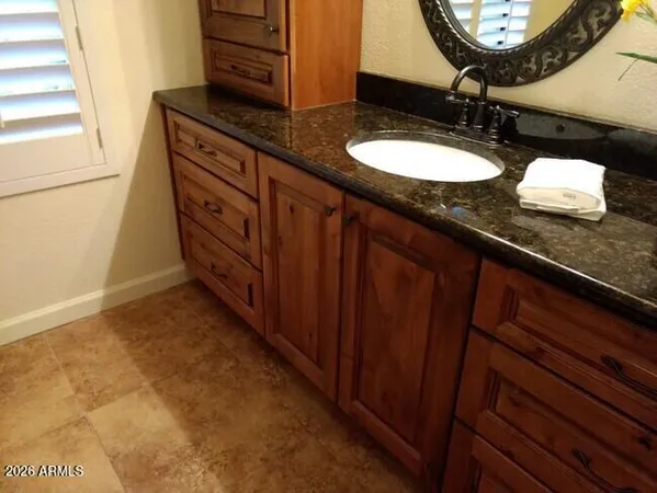a bathroom with a granite countertop sink and a mirror