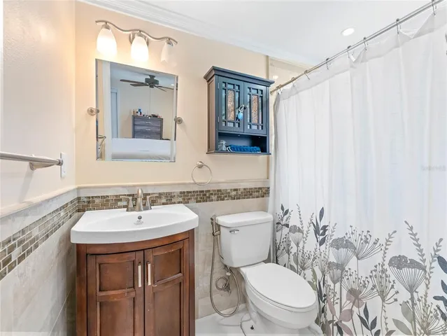 a bathroom with a sink a toilet and shower curtain