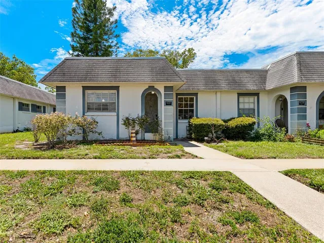 a front view of a house with a yard and potted plants
