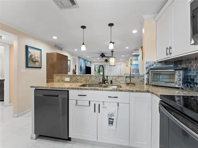 a kitchen with stainless steel appliances granite countertop a sink and a stove