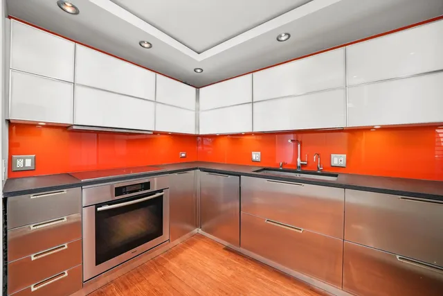 a view of kitchen with stainless steel appliances wooden floor and window