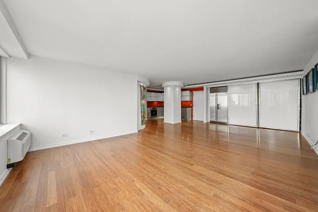 an empty room with wooden floor and white walls