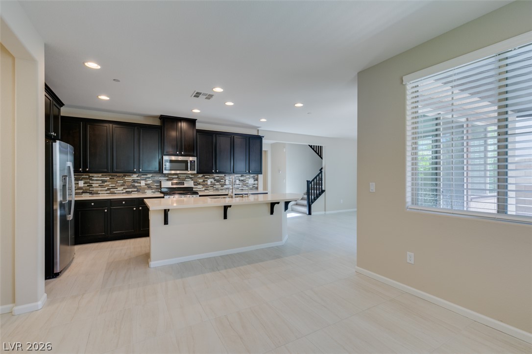2549 Sable Ridge Street Henderson, NV 89044 - Photo 23 of 48 A well-appointed kitchen featuring dark cabinetry and a spacious island, perfect for culinary endeavors.