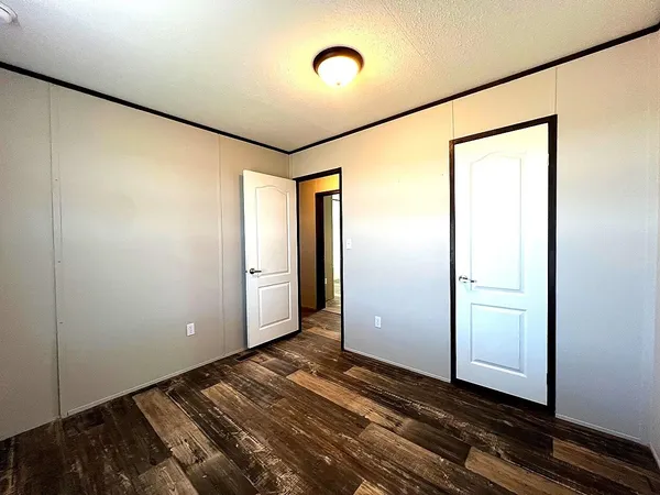 a view of an empty room with window and closet area