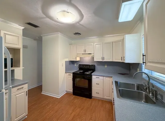 a kitchen with granite countertop a stove and a sink