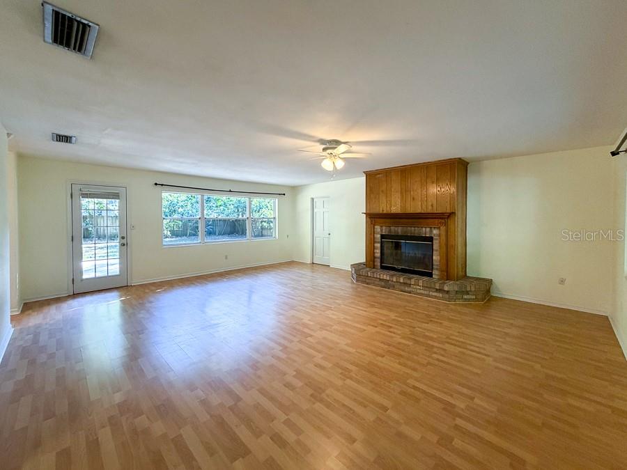 3027 Northwest 1st Avenue Gainesville, FL 32607 - Photo 2 of 31 an empty room with windows fireplace and wooden floor