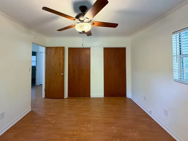 an empty room with closet and a ceiling fan