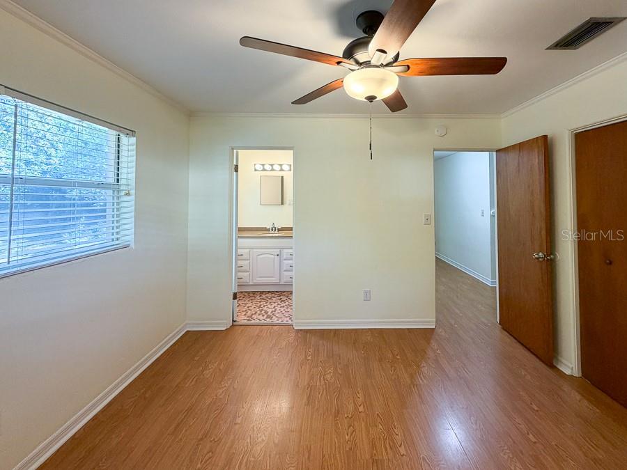 3027 Northwest 1st Avenue Gainesville, FL 32607 - Photo 22 of 31 an empty room with wooden floor chandelier fan and windows
