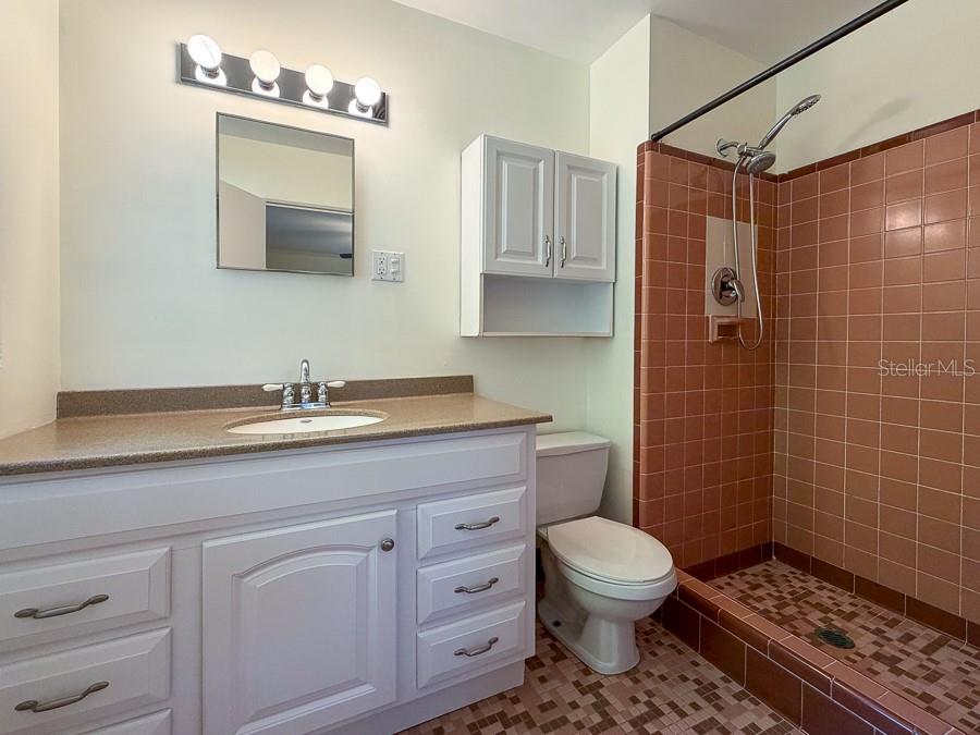 3027 Northwest 1st Avenue Gainesville, FL 32607 - Photo 24 of 31 a bathroom with a toilet a sink a window and mirror