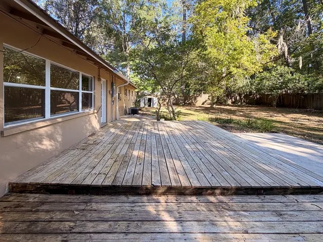 a view of backyard with wooden floor and fence