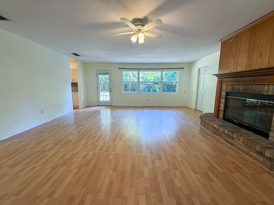 3027 Northwest 1st Avenue Gainesville, FL 32607 - Photo 3 of 31 an empty room with windows fireplace and a kitchen view