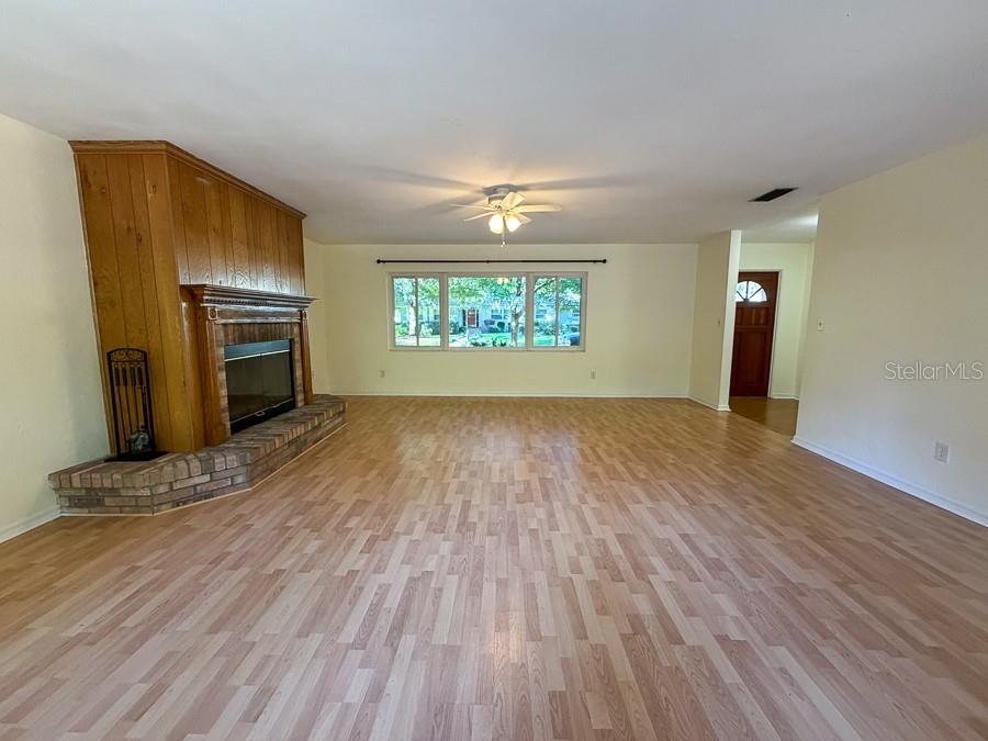 3027 Northwest 1st Avenue Gainesville, FL 32607 - Photo 5 of 31 an empty room with wooden floor fireplace and windows