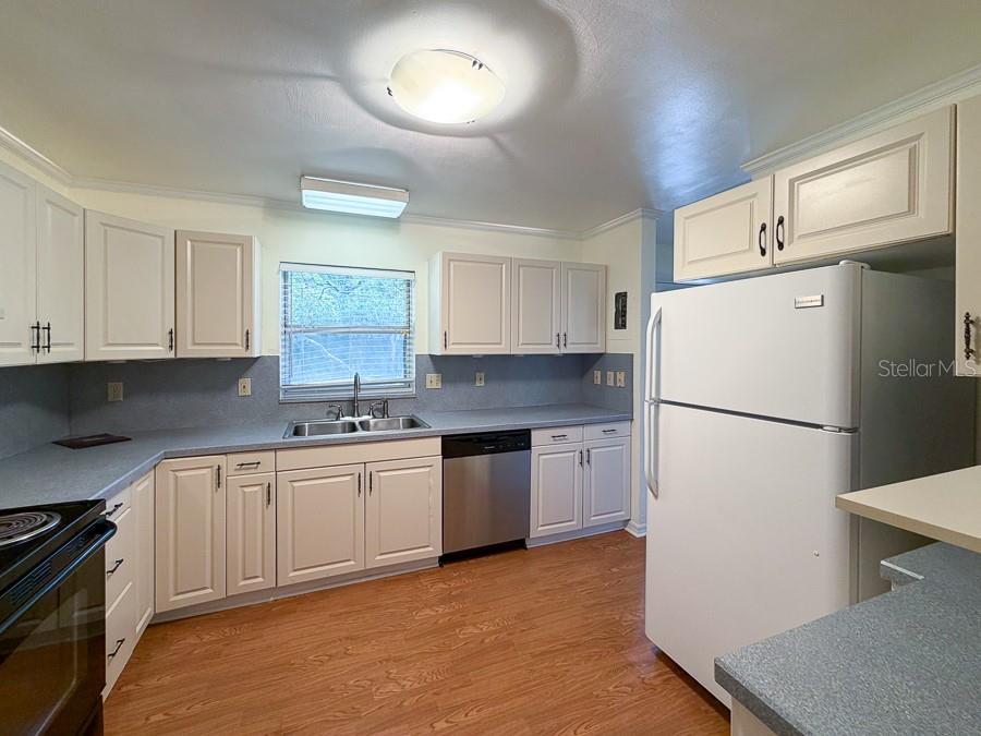 3027 Northwest 1st Avenue Gainesville, FL 32607 - Photo 10 of 31 a kitchen with a refrigerator sink and cabinets