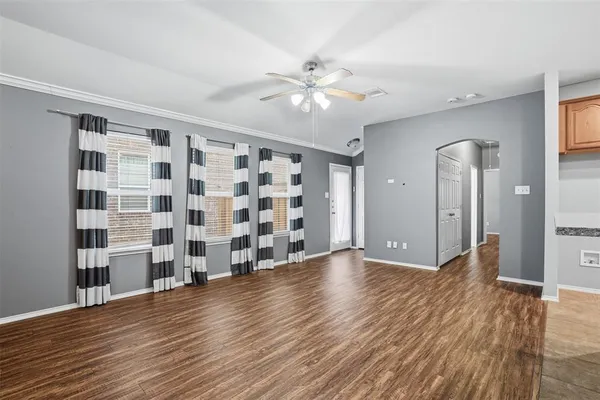 a view of an empty room with a window and wooden floor