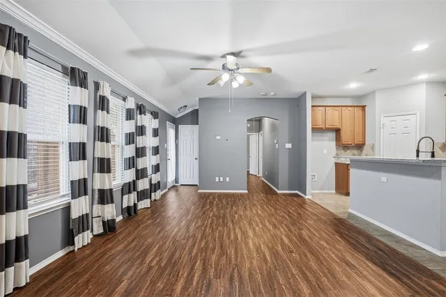 a kitchen with stainless steel appliances granite countertop a stove top oven a sink a refrigerator and white cabinets