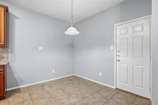 an empty room with chandelier fan