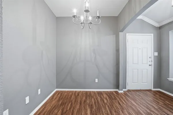 a view of a room with a chandelier fan and wooden floor