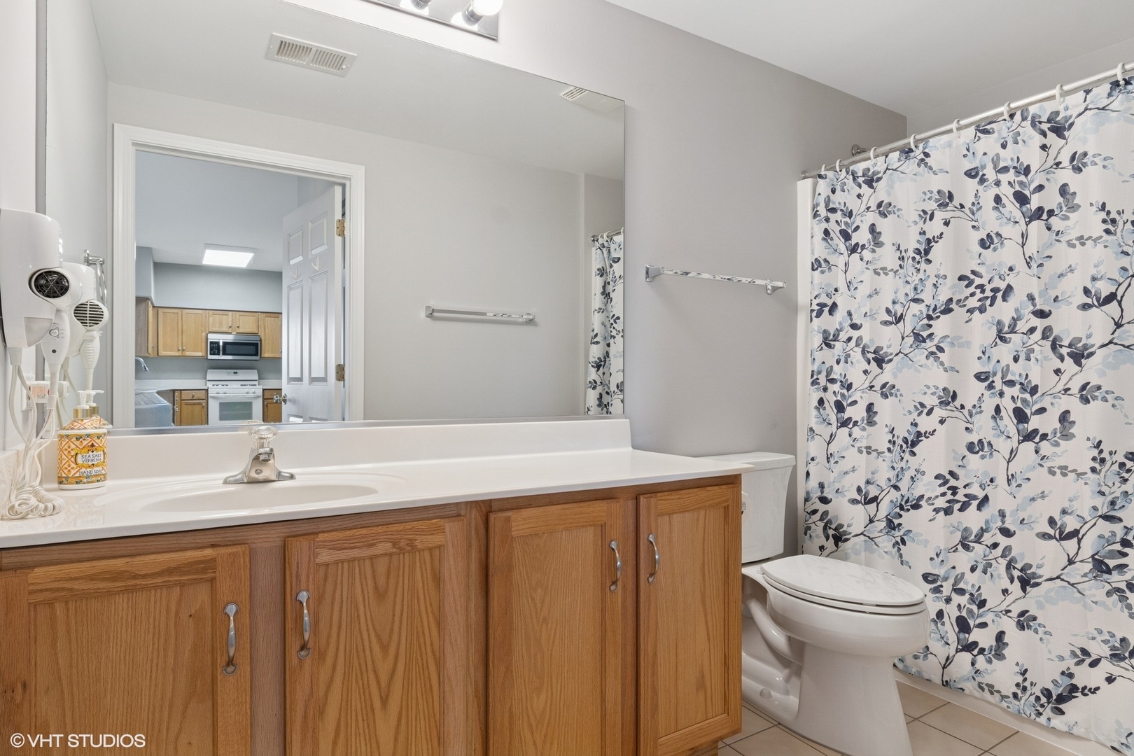 -s099 Lee Court, Unit 401 Winfield, IL 60190 - Photo 13 of 19 a bathroom with a granite countertop toilet a sink a mirror and shower curtain